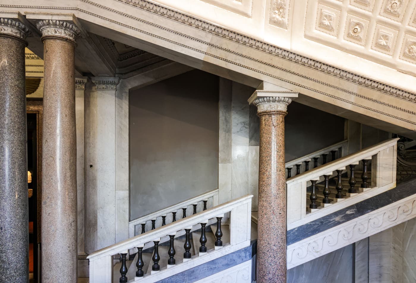 Classical colonnade and grand staircase in a marble interior