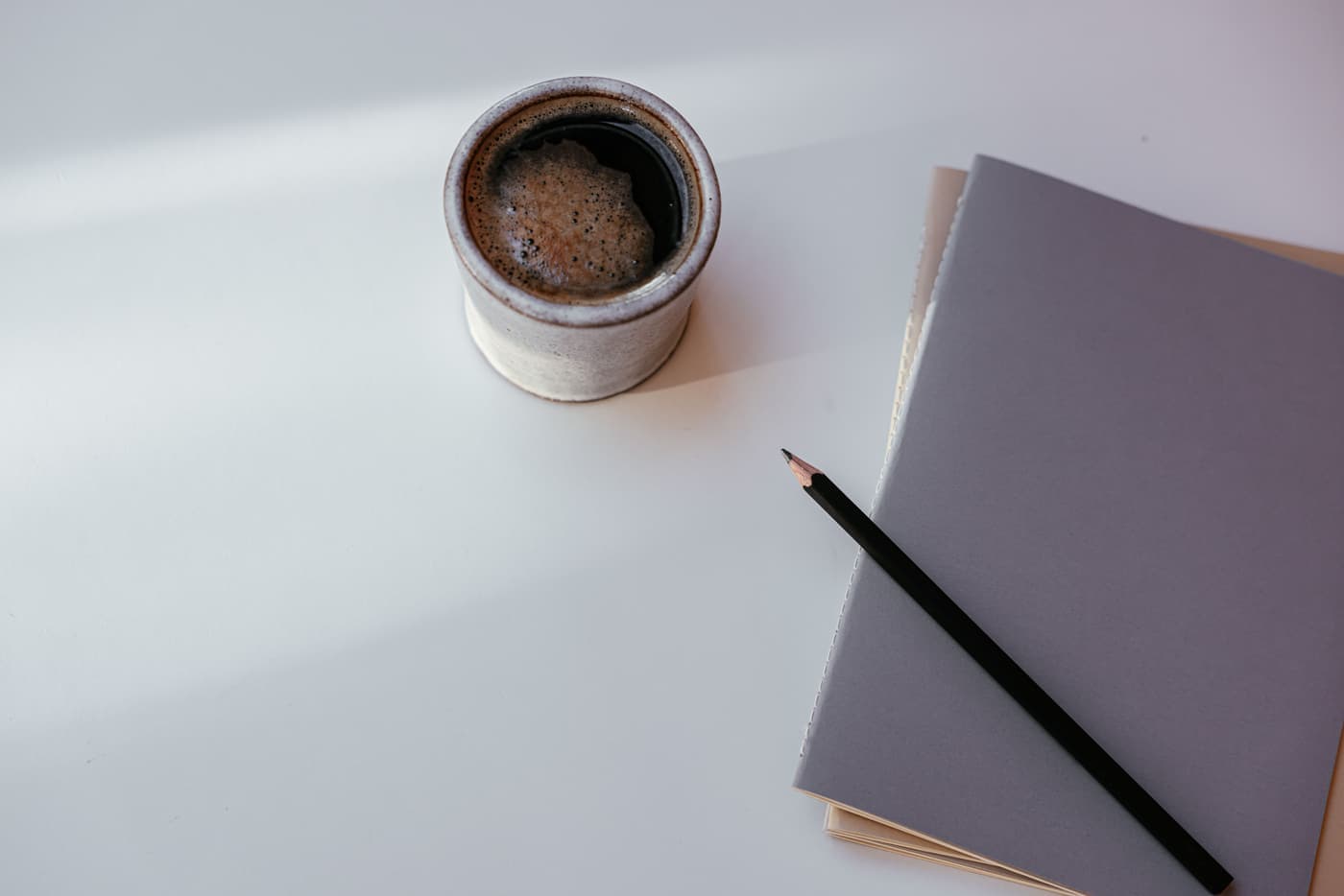 Notebook, pencil and a cup of coffee on a quiet study desk