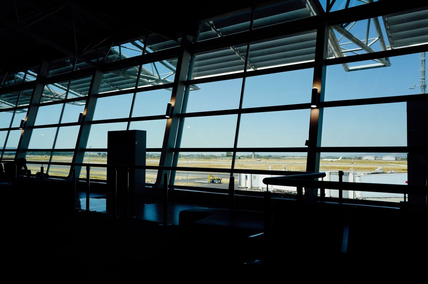 View from inside an airport terminal looking out across the runway