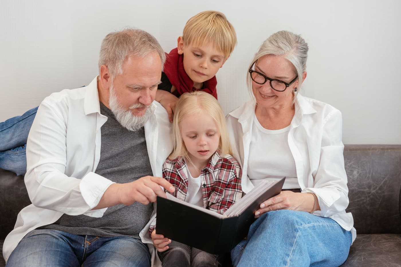 Grandparents and grandchildren looking through a photo album together