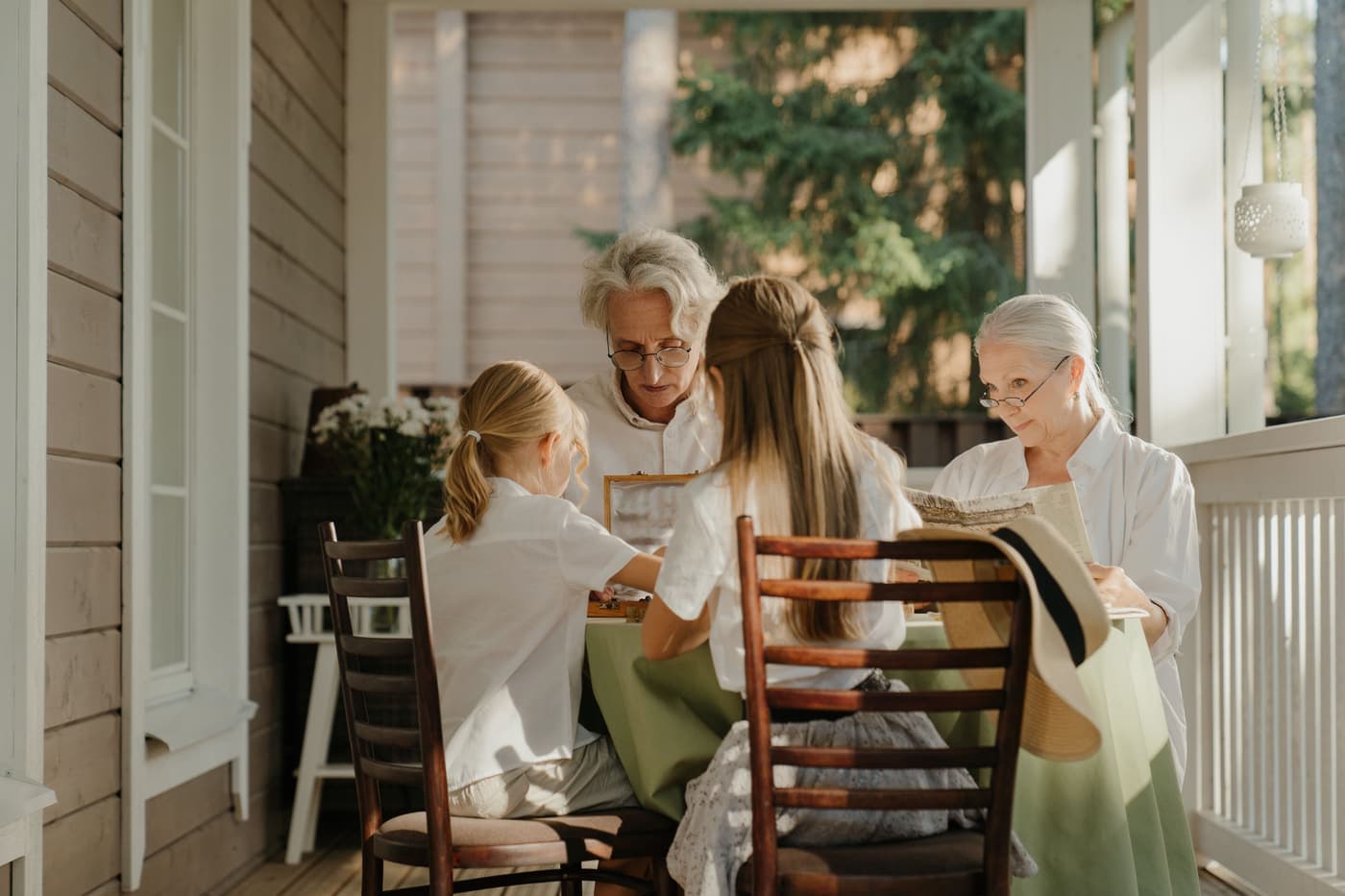 Three generations of a family sharing a moment on a sunlit veranda