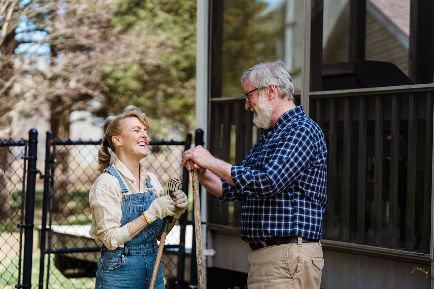 Older couple talking together while gardening in their backyard
