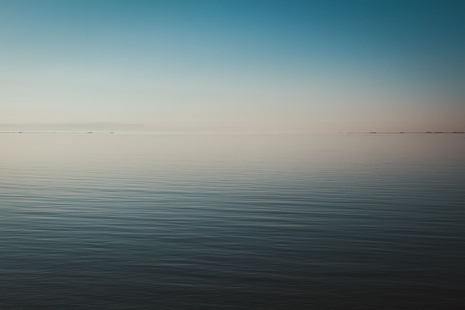 Tranquil sea horizon at dawn with calm water and clear sky
