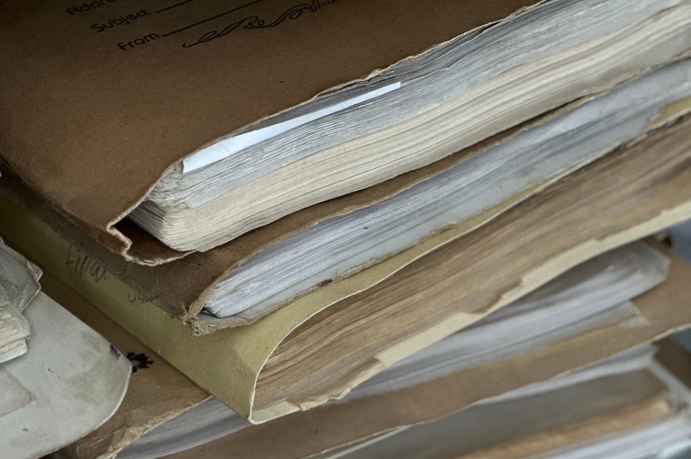 Aged brown paper folders stacked and archived in close-up