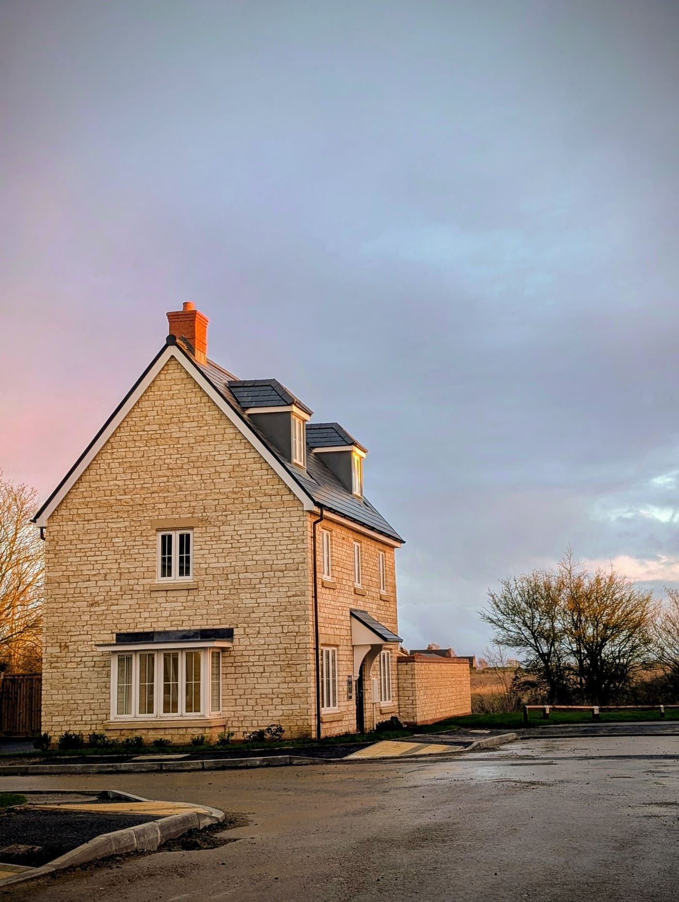 A family home in the countryside lit by late golden light.