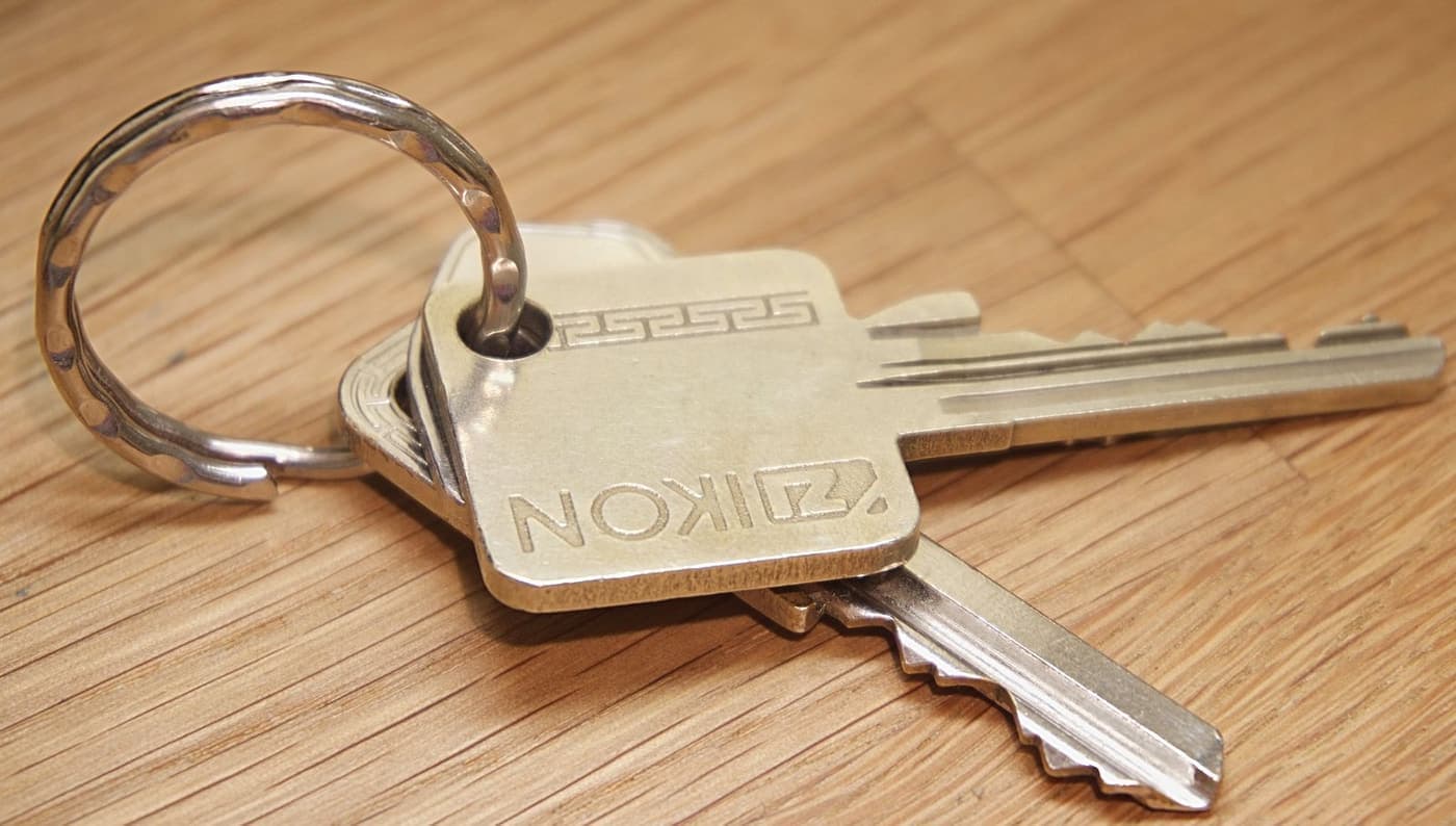A set of house keys lying on a worn wooden table.