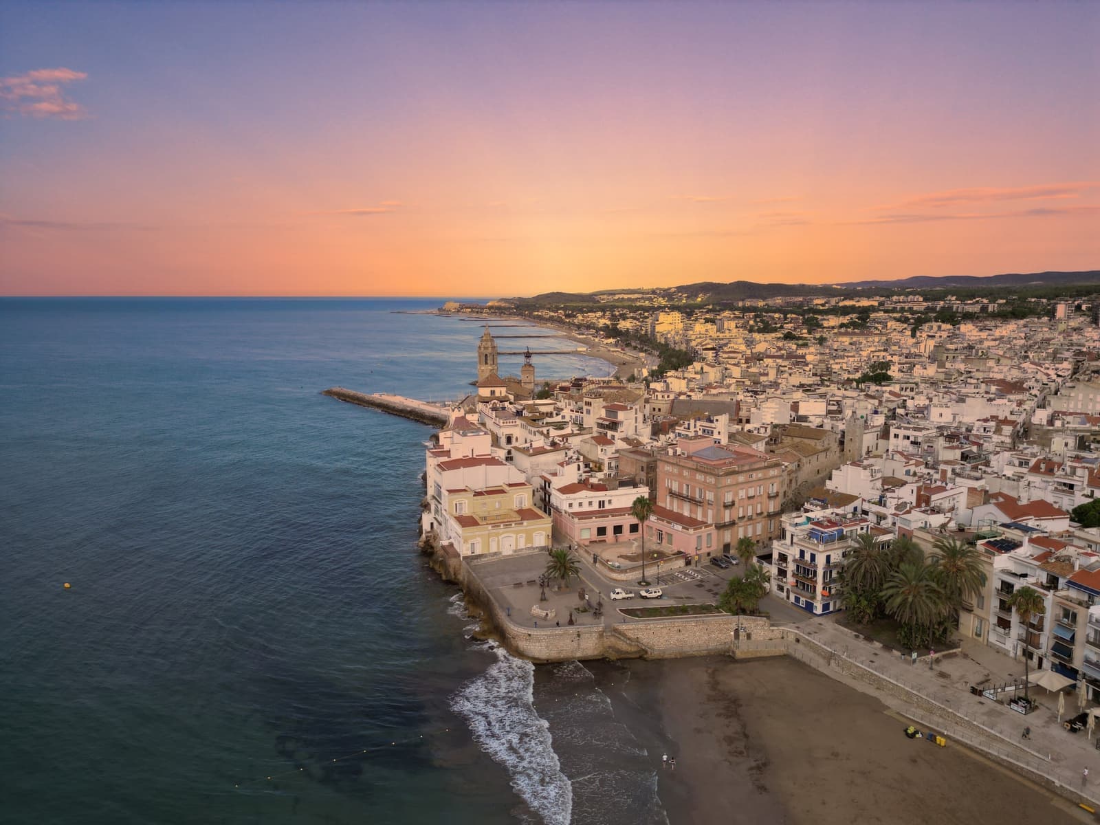 A coastal town seen from the sea at golden hour, the kind of place a UK pension follows its owner to