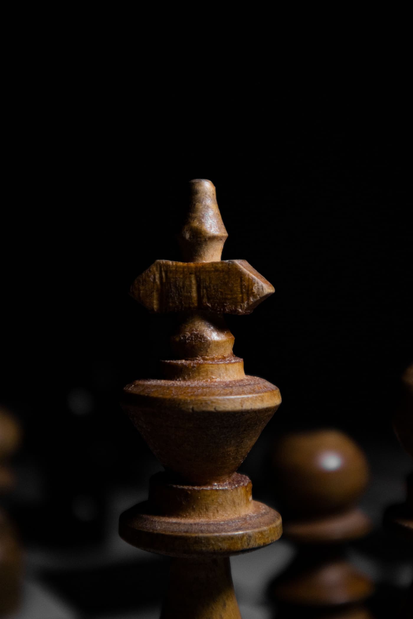 Wooden chess king in close-up against a dark background