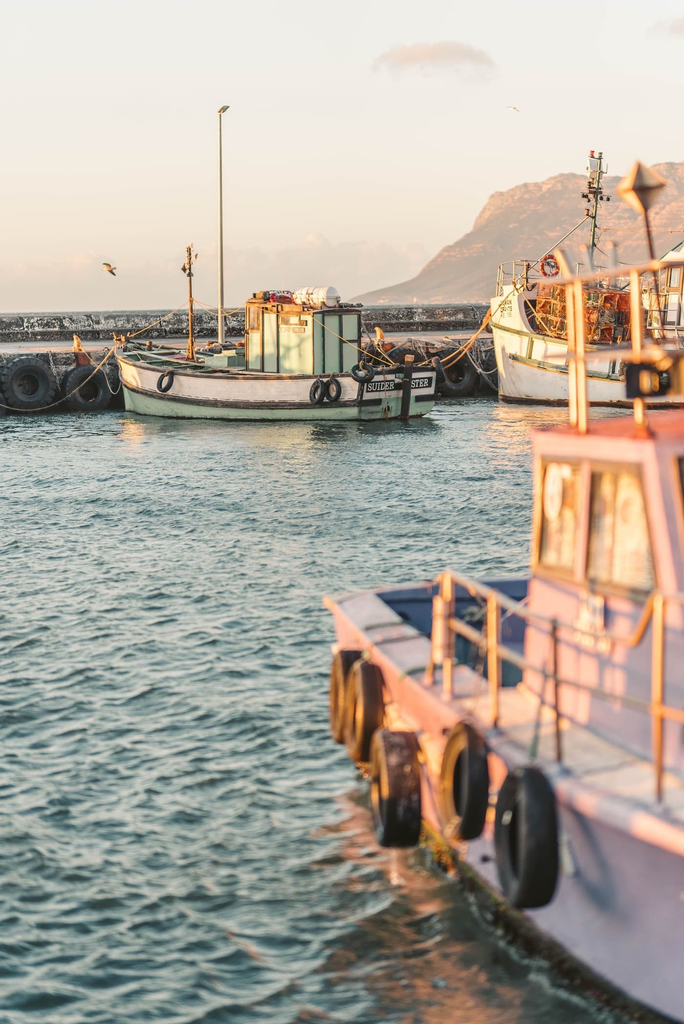 Fishing boats moored in a quiet harbour at sunrise
