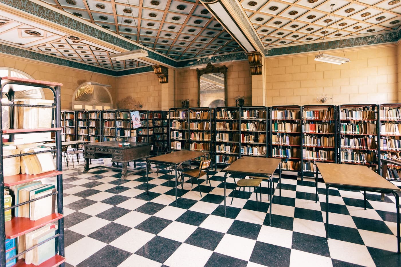 Empty reading hall of a historic library with a chequered stone floor