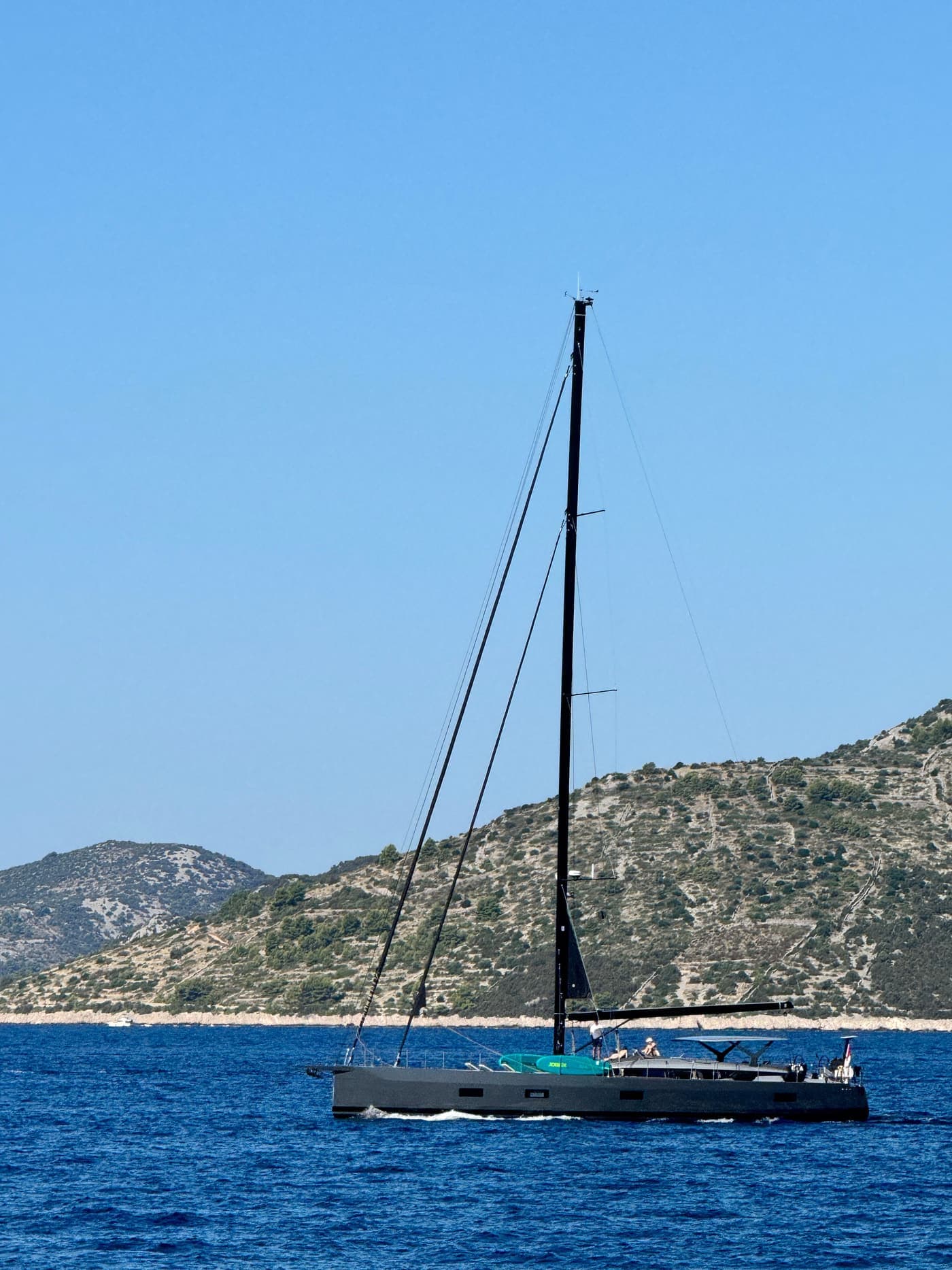 Yacht sailing on the blue Mediterranean with a coastal backdrop