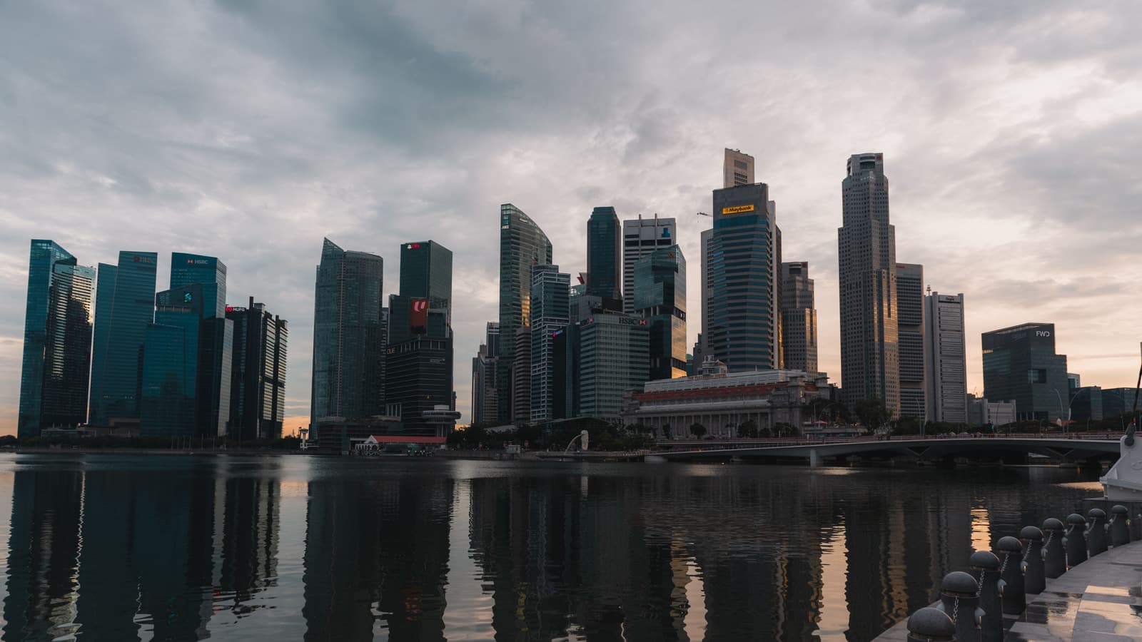 Singapore waterfront skyscrapers mirrored in the bay at dusk