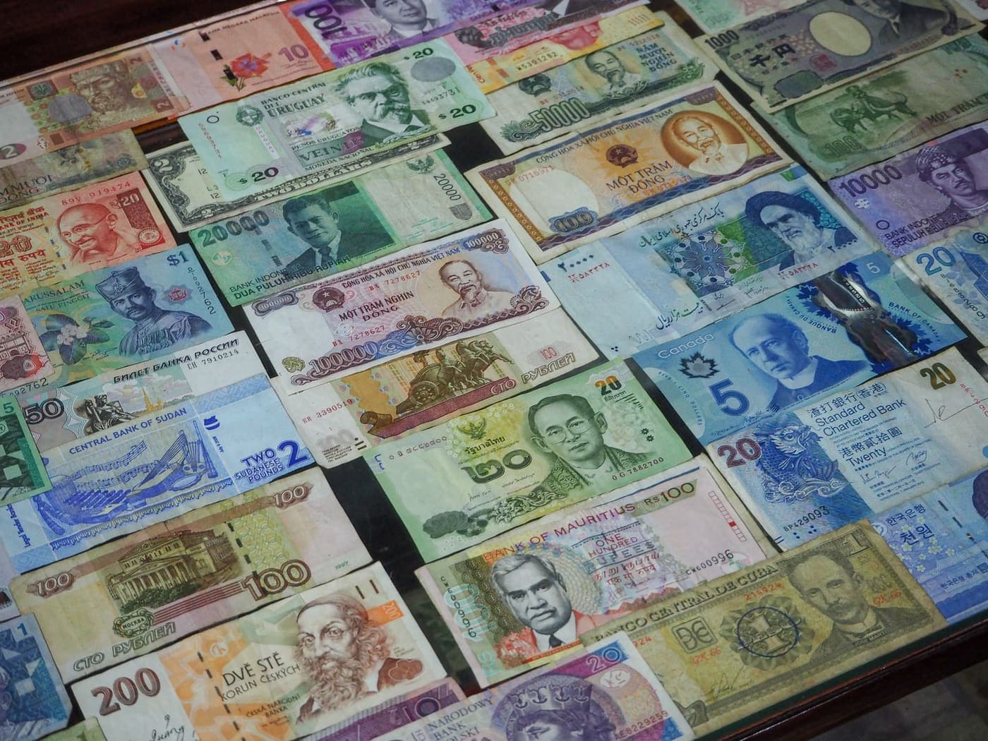 Banknotes from several countries laid out in a row.