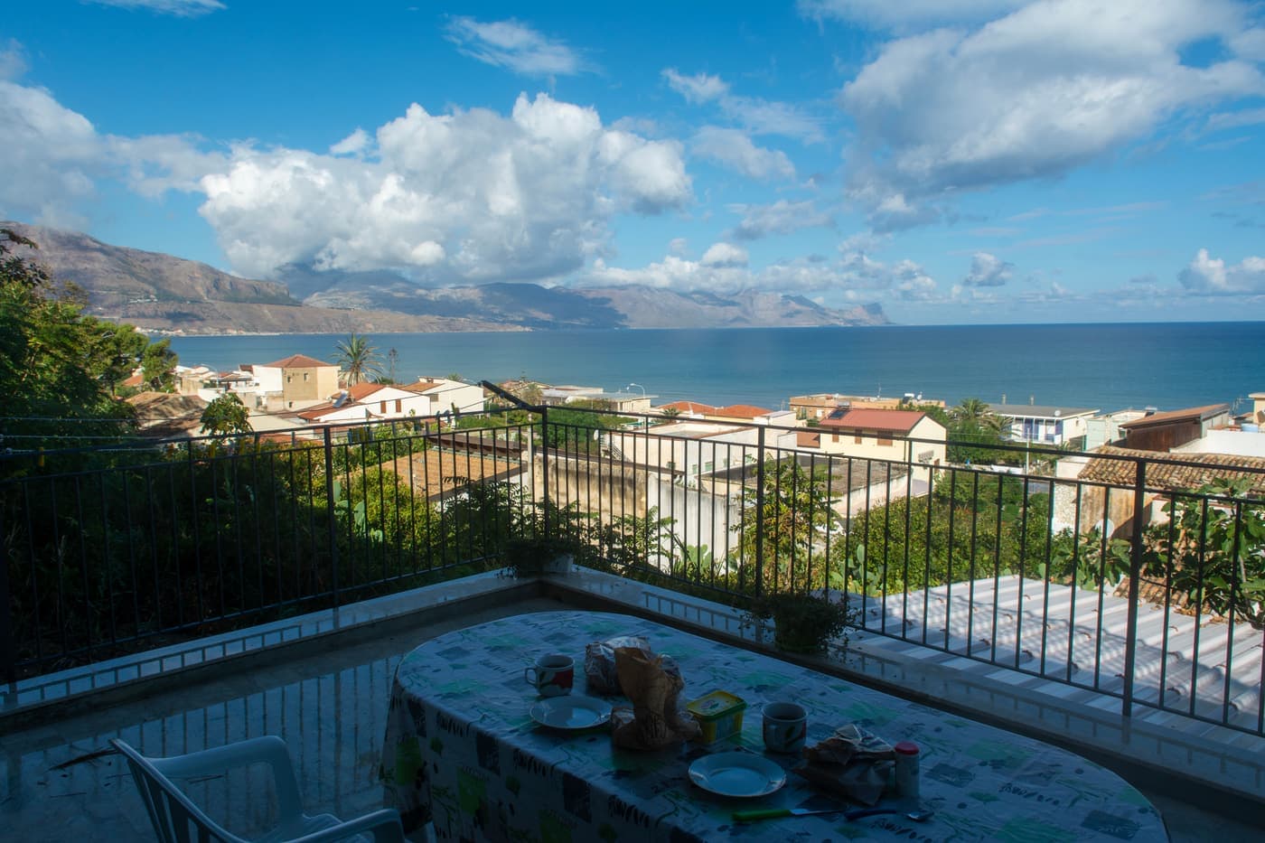 Breakfast laid on a terrace table overlooking the sea in Sicily