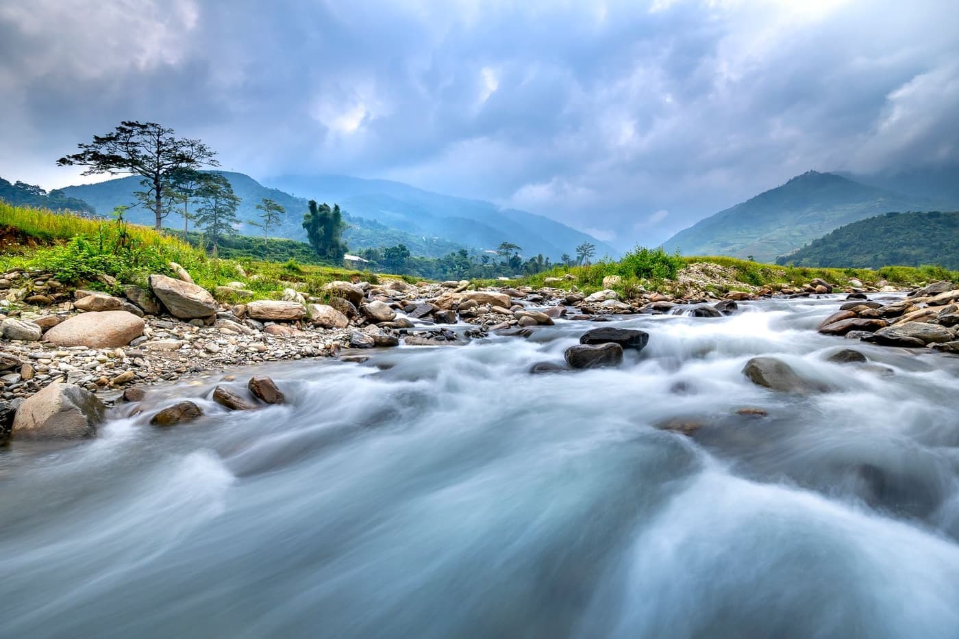 A mountain river running steadily through a green valley.