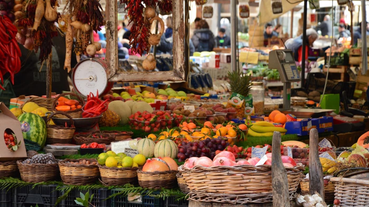 Fruit and vegetables piled on an outdoor market stall.