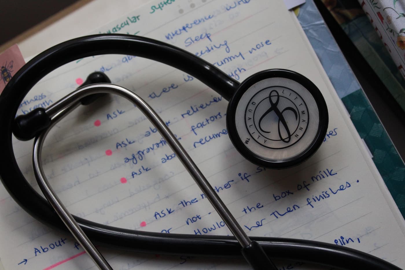 A stethoscope resting on written notes on a desk.