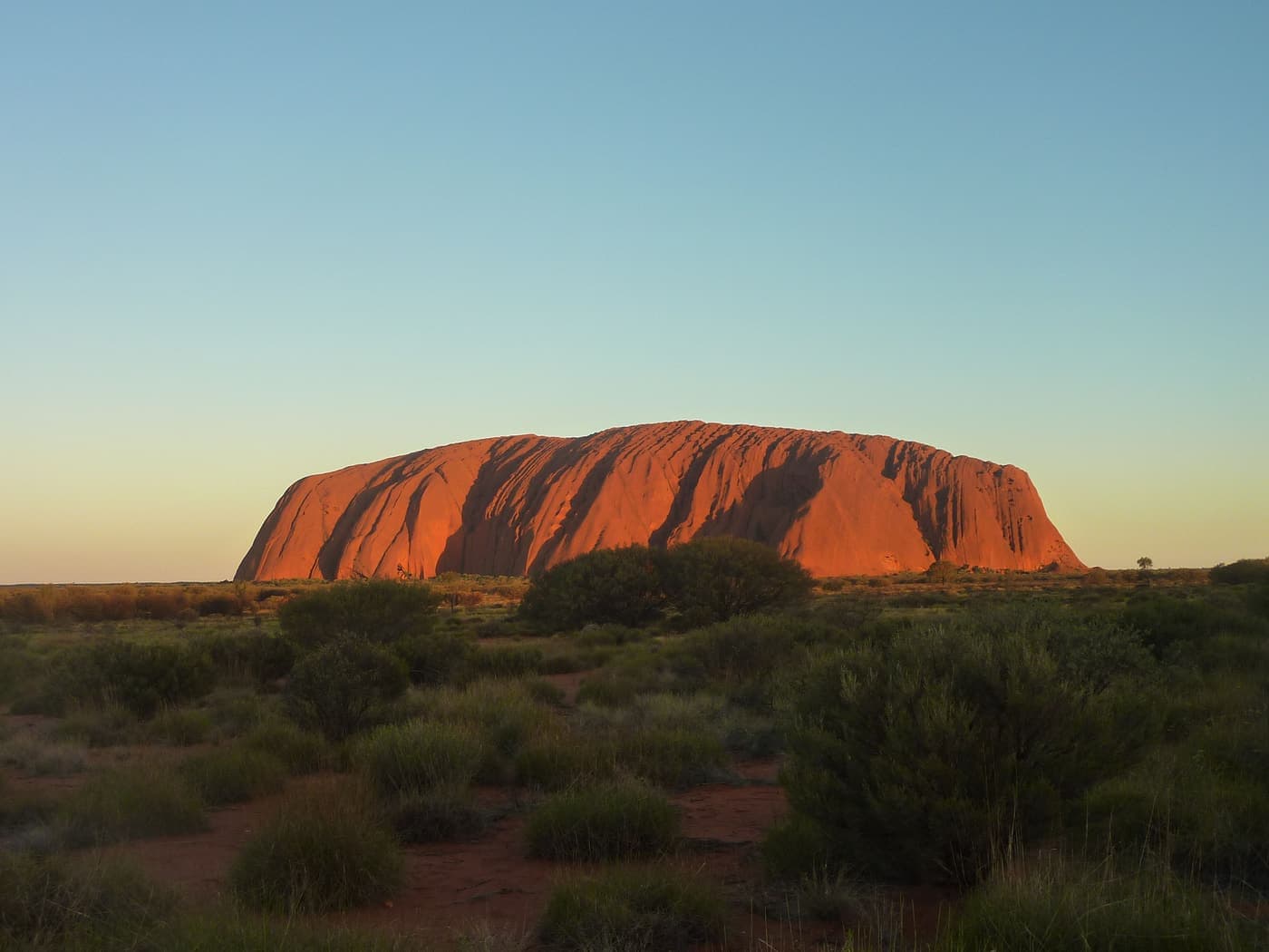Uluru glowing red at sunset in the Australian outback