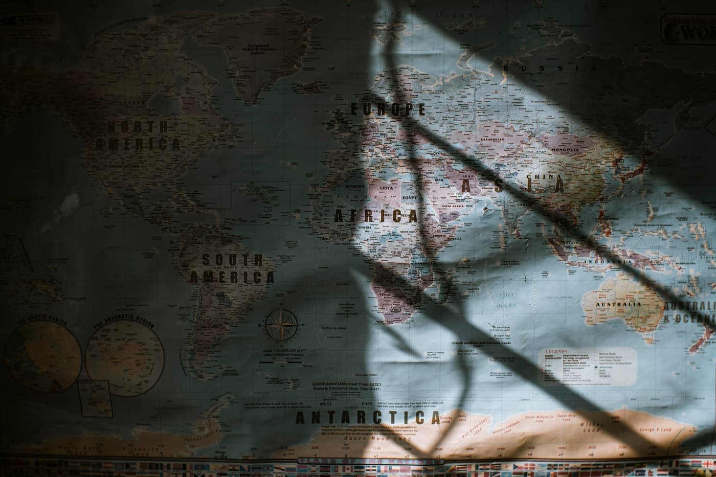 Aged world map hanging on a wall in low sunlight